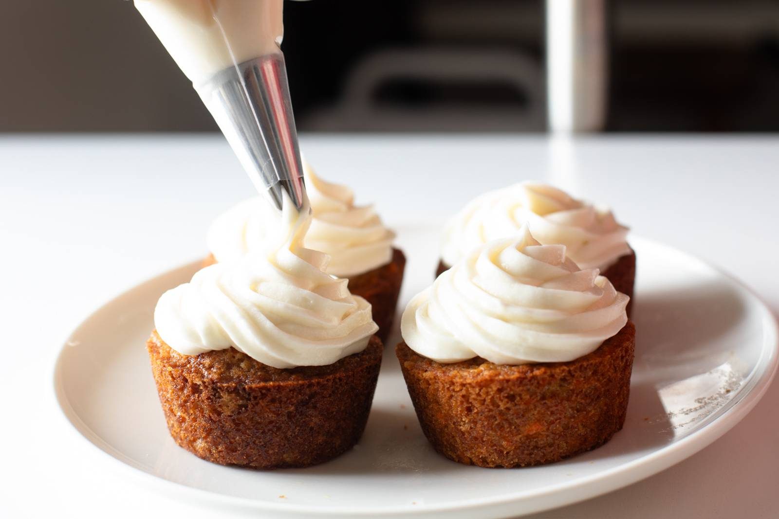 Frosting cupcakes on a plate.