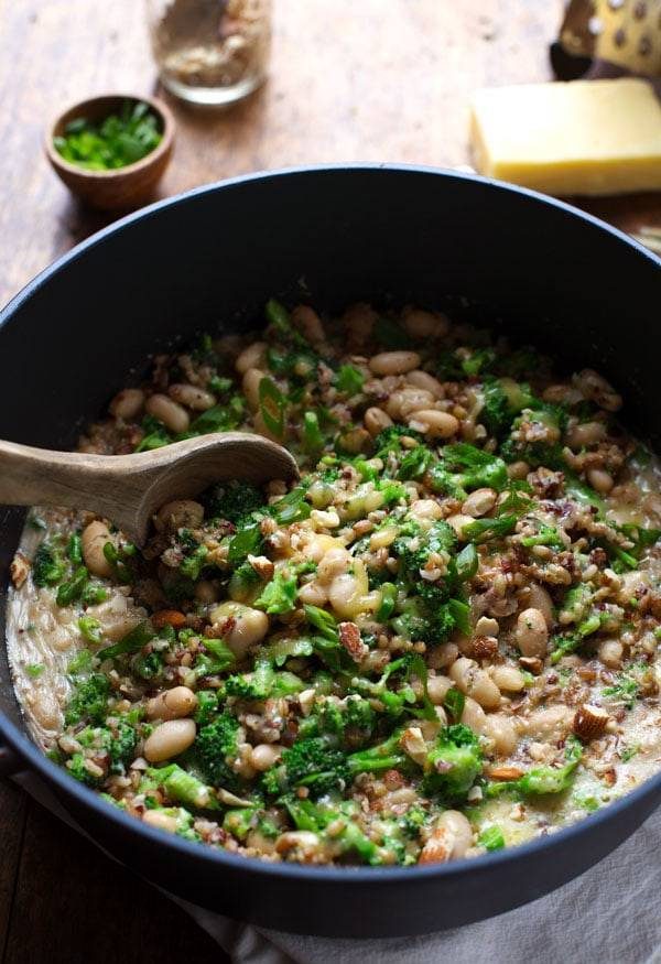 Broccoli Cheese Rice in a pan with a wooden spoon.