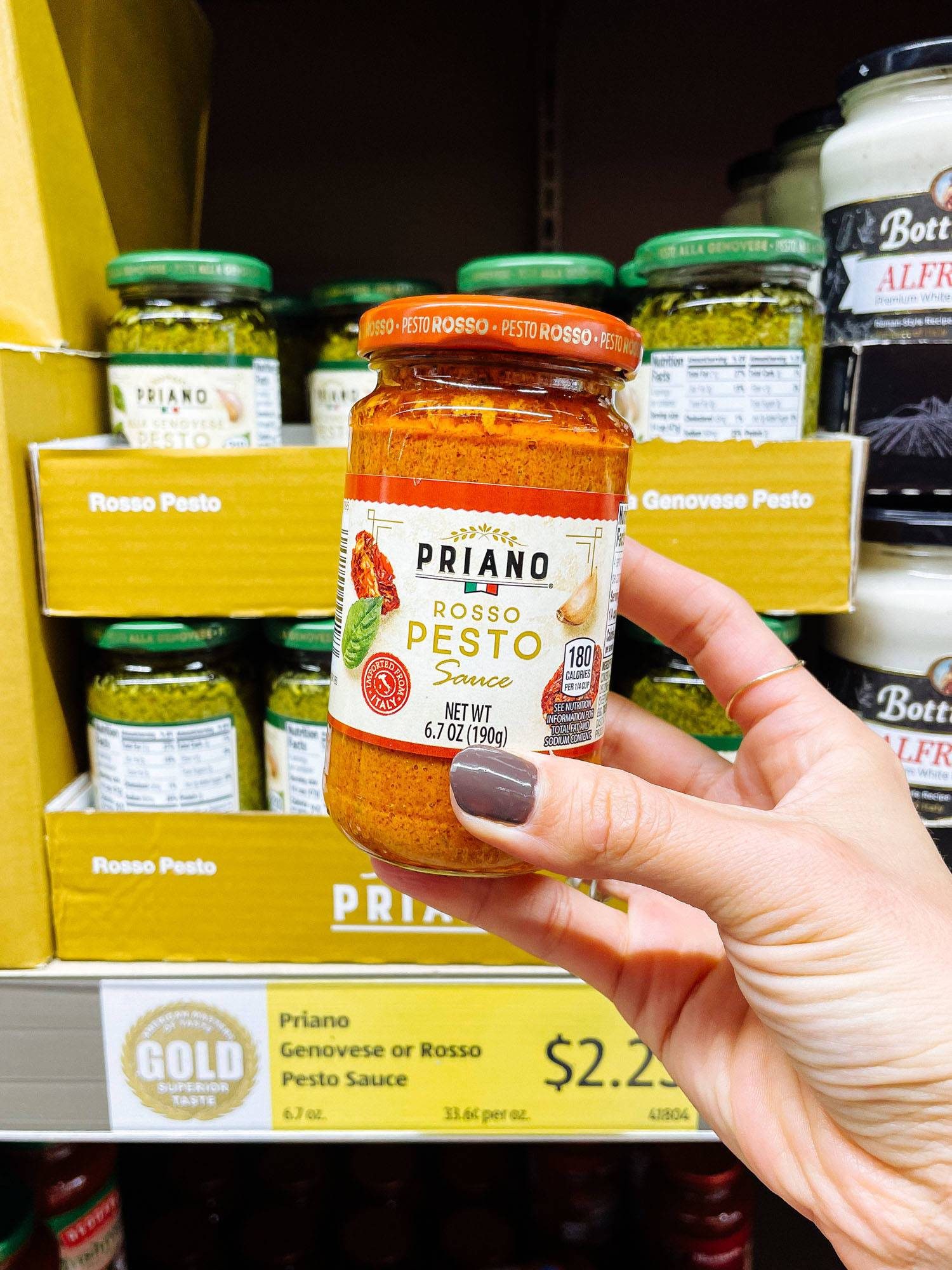 White hand holding rosso pesto from ALDI.