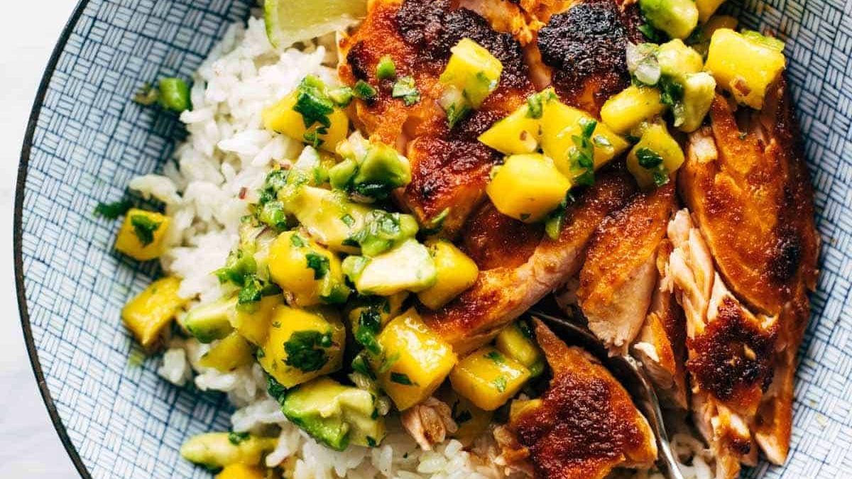 BBQ salmon in a bowl with mango salsa and rice.
