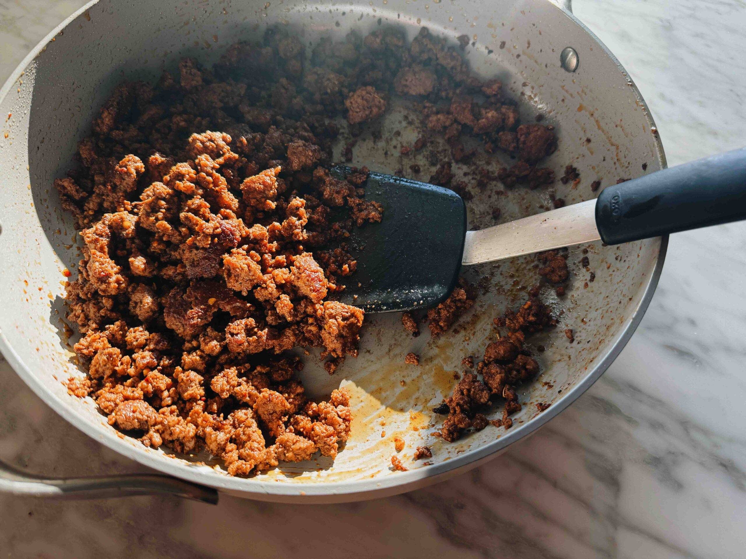 Sautéing beef in a skillet.