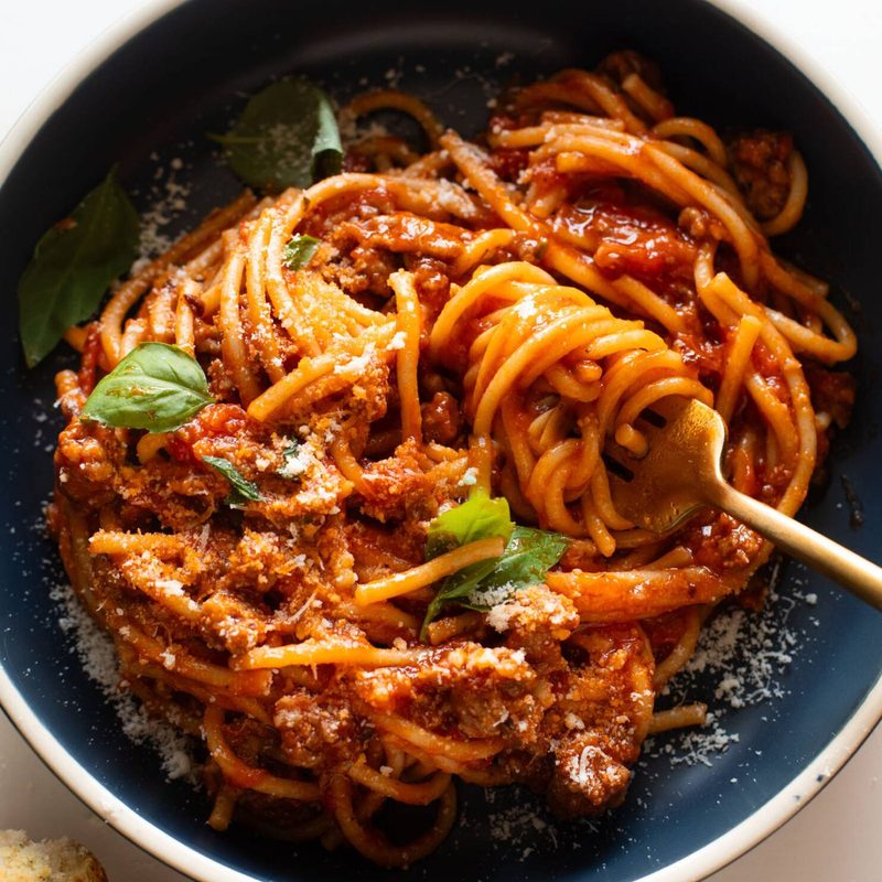 Instant Pot spaghetti in a bowl with basil and parmesan