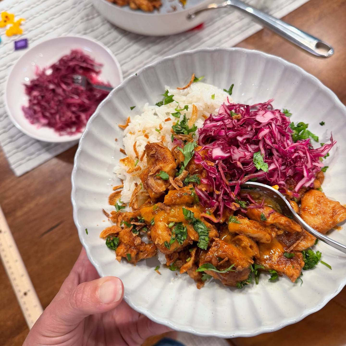 Peanut chicken with rice and slaw on a plate.