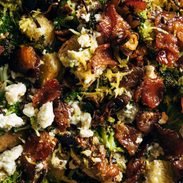 A broccoli salad with with bacon and croutons in it.