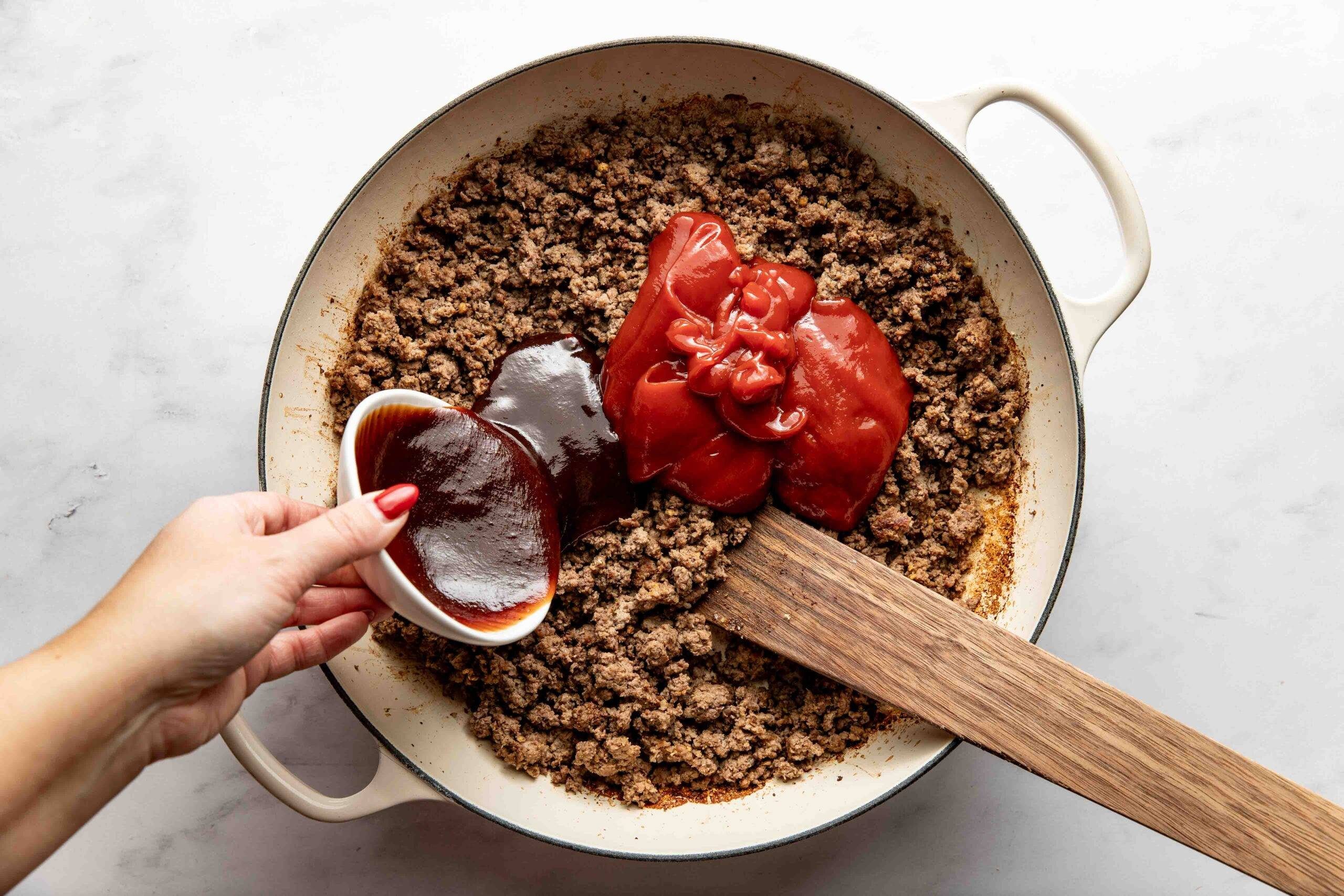 Adding sauces and spices to ground beef.