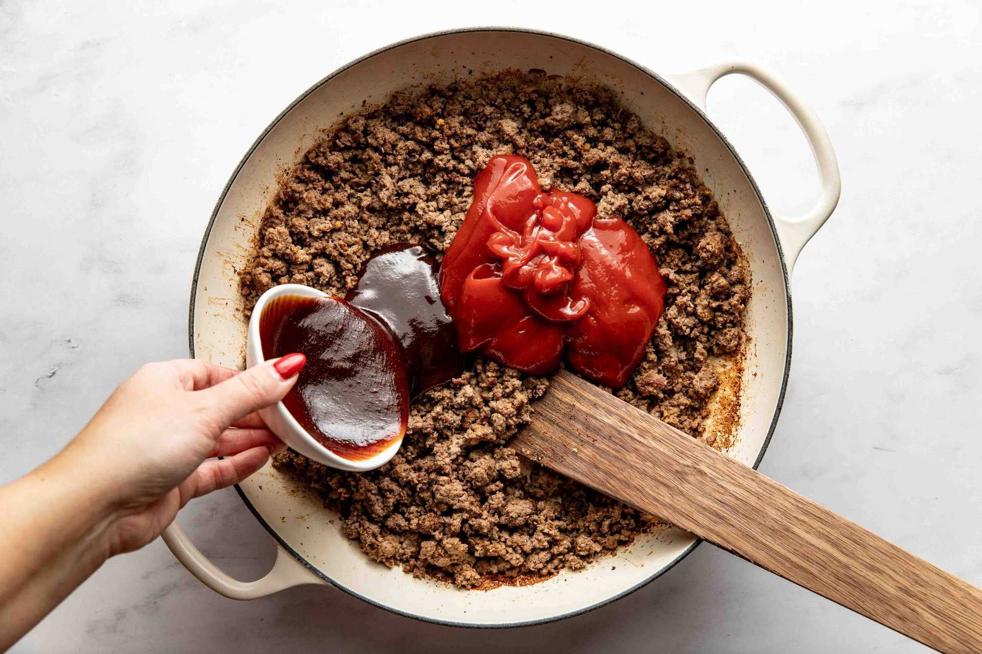 Adding sauces and spices to ground beef.