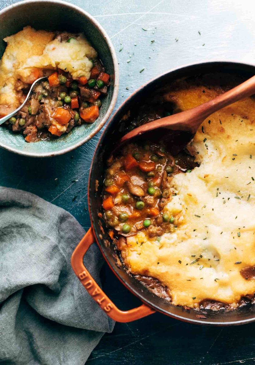 Meatless shepherd's pie being spooned out of a red pot.