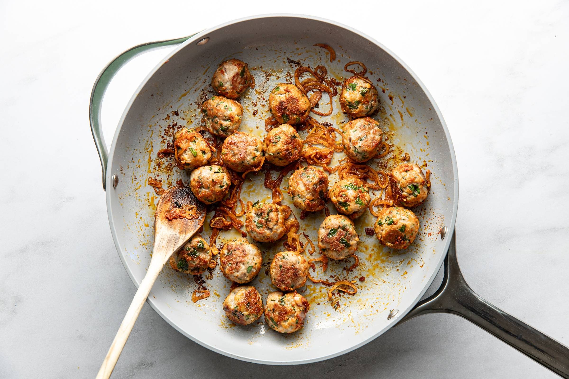 Cooking meatballs with shallots and curry paste.