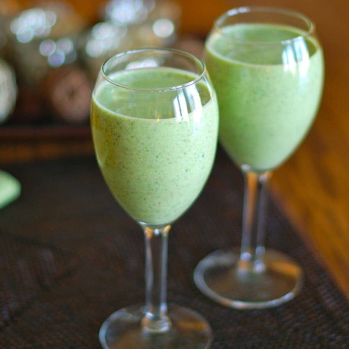 Two green monster smoothies in glasses.