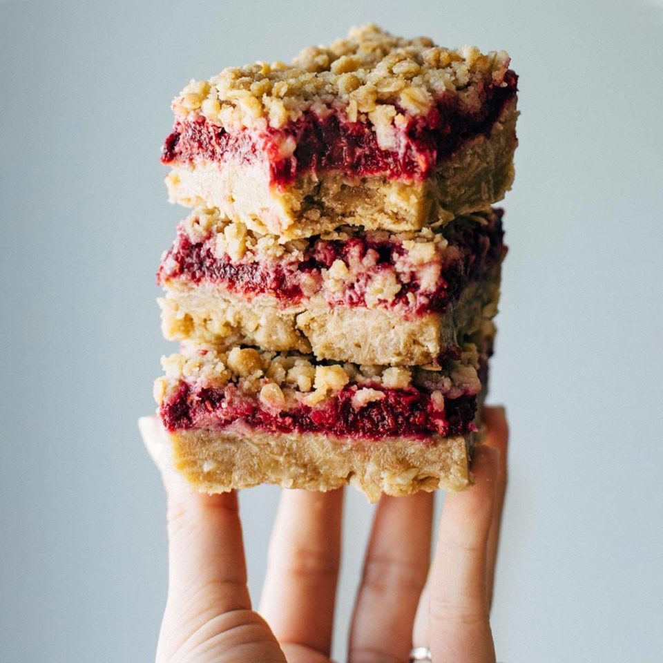 Three Raspberry Crumble Bars stacked on top of each other.