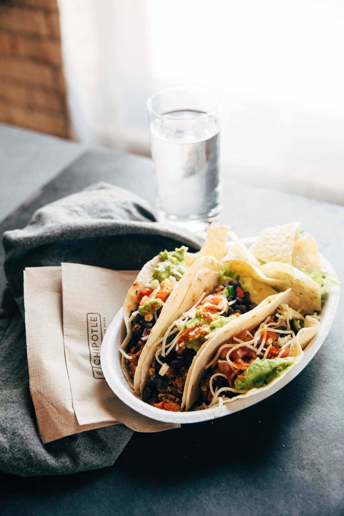 Chipotle on a napkin with a glass of water.