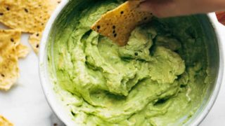 Avocado Dip in a bowl with chip.