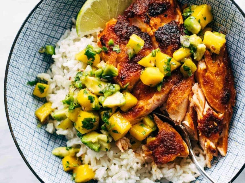 BBQ salmon in a bowl with mango salsa and rice.