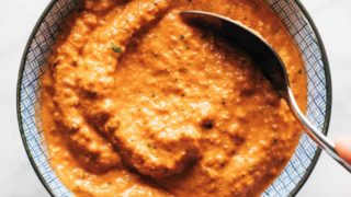 Romesco sauce in a bowl with a spoon.