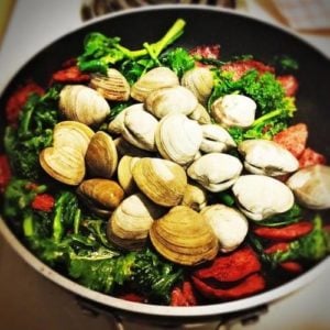 Clam shells with veggies in a skillet.