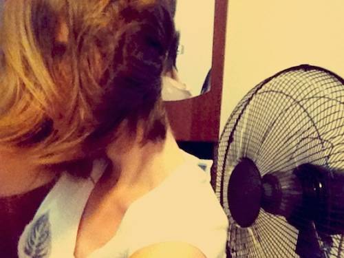 Woman drying her hair with a fan.