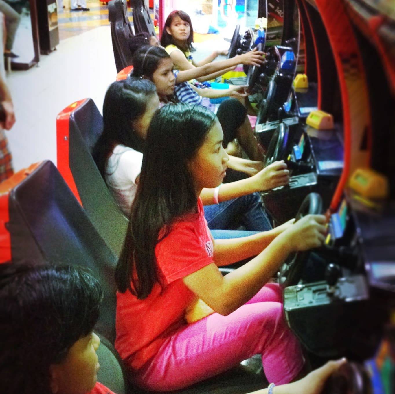 Young girls playing at an arcade.