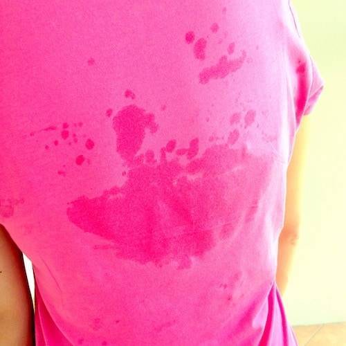 Pink shirt with sweat spots.