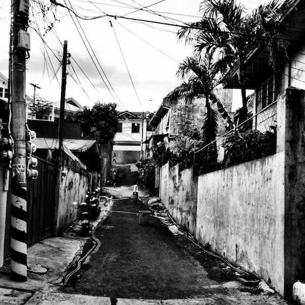 Black and white sidewalk off of a street.