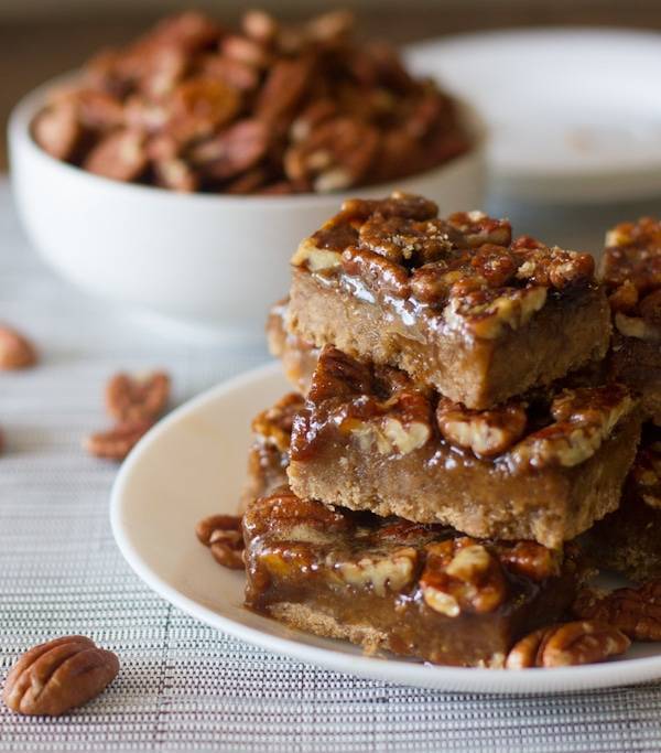 Salted maple pecan pie bars stacked on a plate.