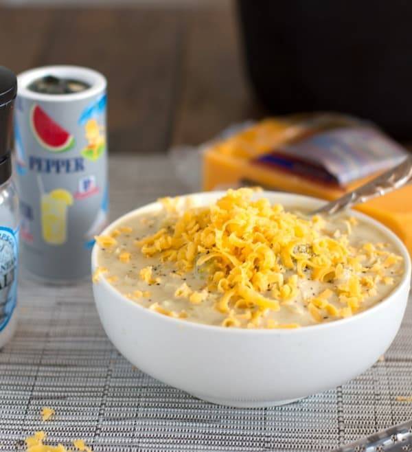 Crockpot Broccoli Cheese Soup in a bowl with cheese topping.