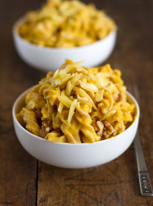 Squash mac and cheese with walnuts in two white bowls.