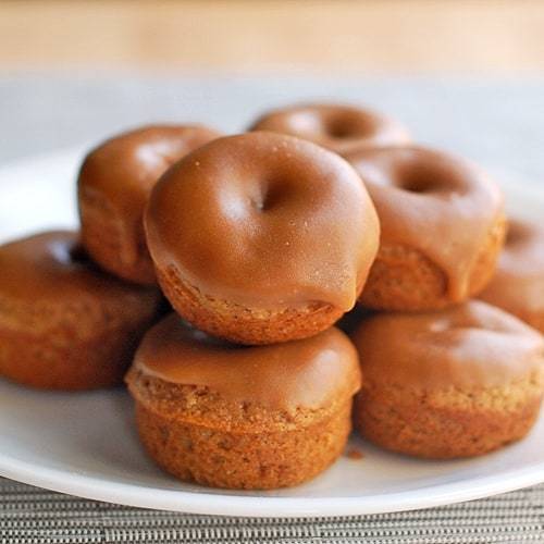 Baked gingerbread donuts on a white plate.
