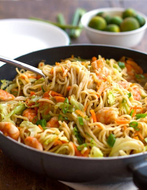 Stir fried noodles with shrimp and vegetables in a skillet.
