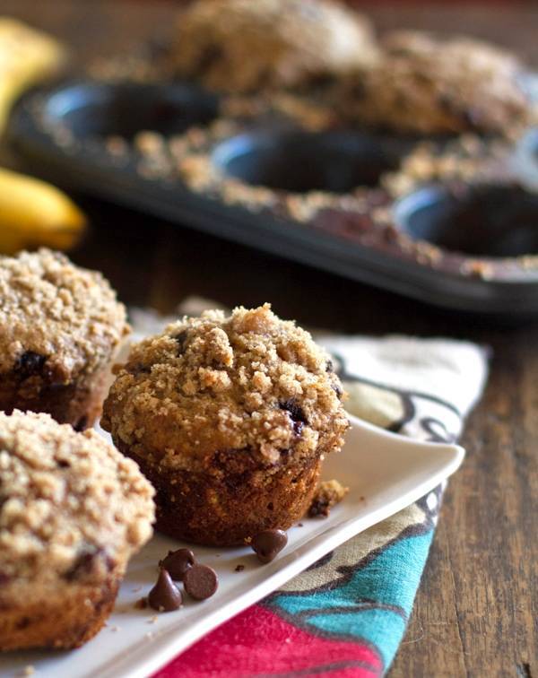 Whole wheat chocolate chip banana peanut butter muffins on a white plate.