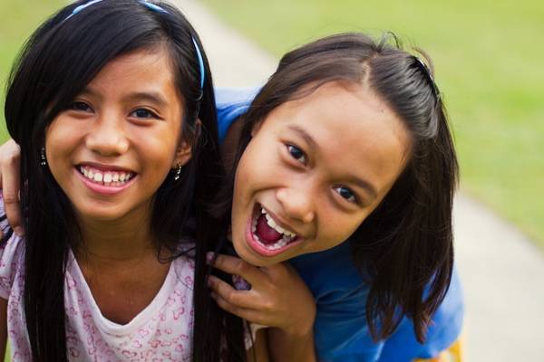 Young girls smiling at a camera.