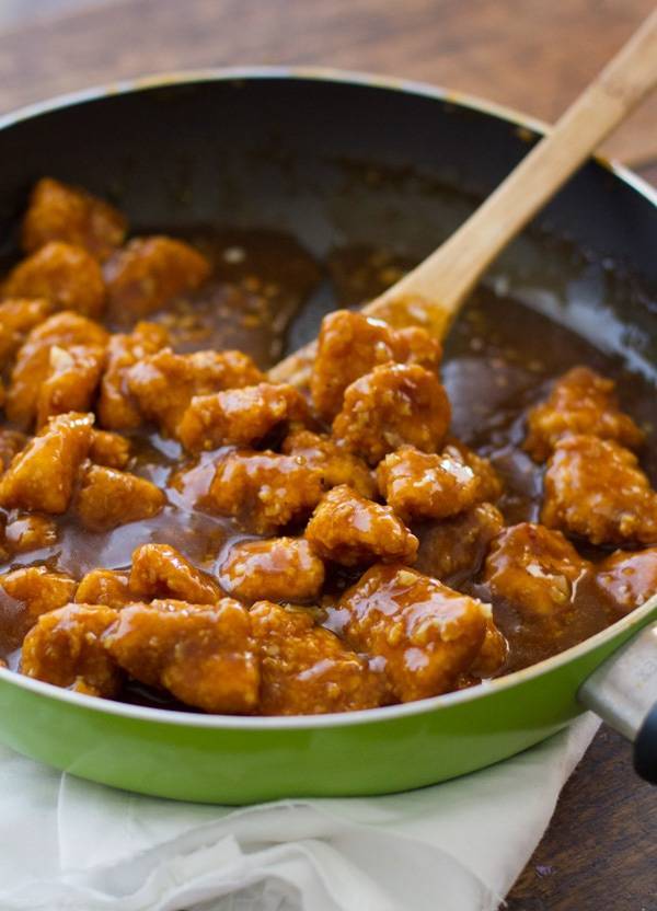 General Tso's Chicken in a skillet with a wooden spoon.