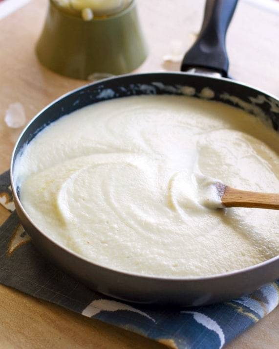 Cauliflower sauce in a skillet with a wooden spoon.