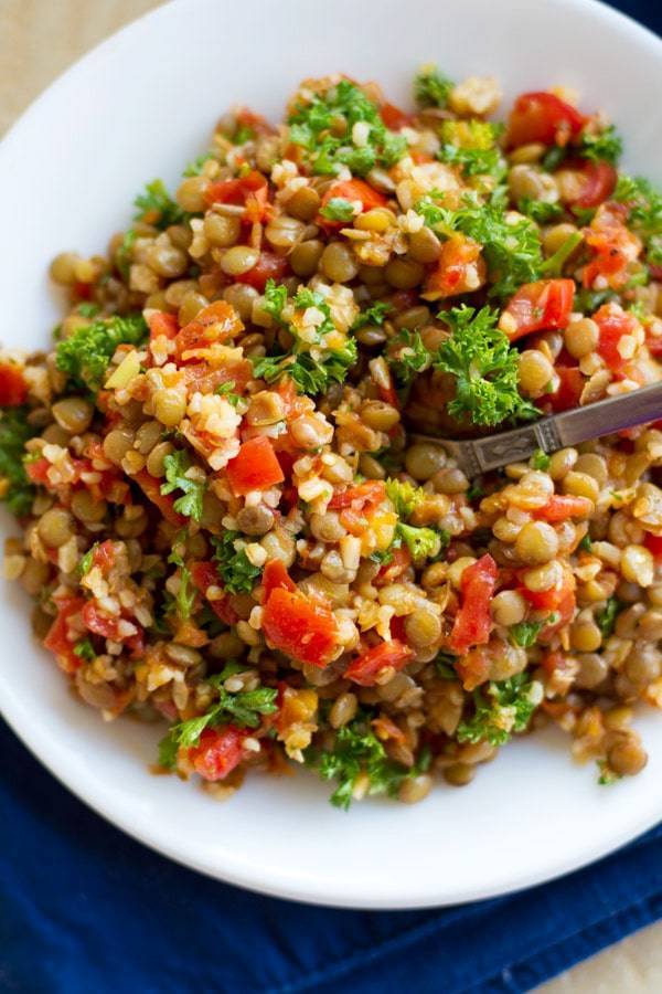Garlic and tomato lentil salad with white plate.