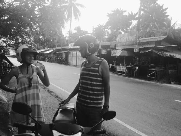 People with helmets standing near the street.