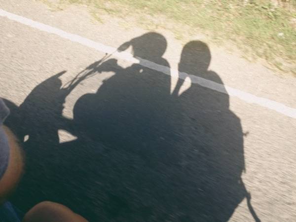 Shadows of people riding on a motor bike.