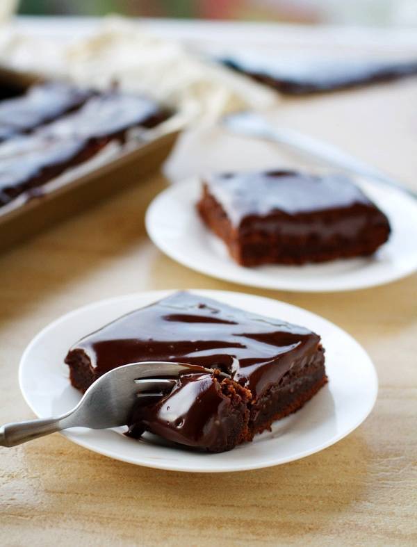 Fudgy chocolate cake bars on a white plate.