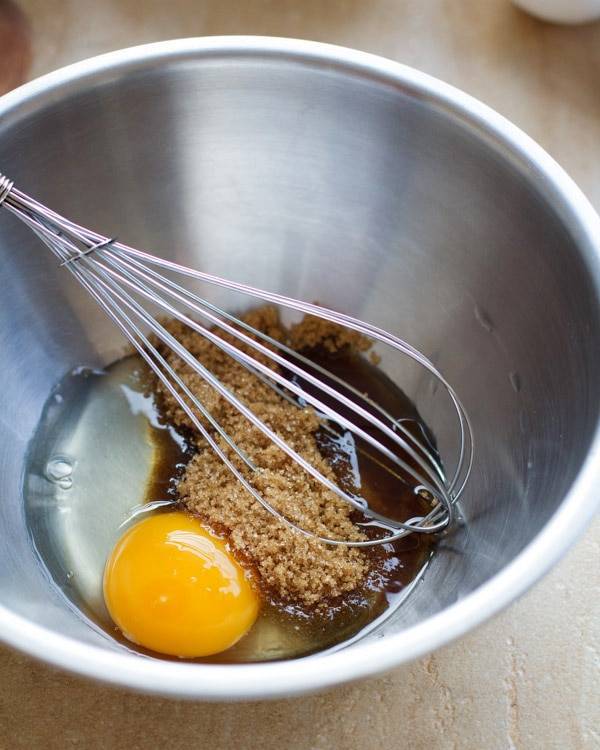Egg and brown sugar in a mixing bowl with a whisk.
