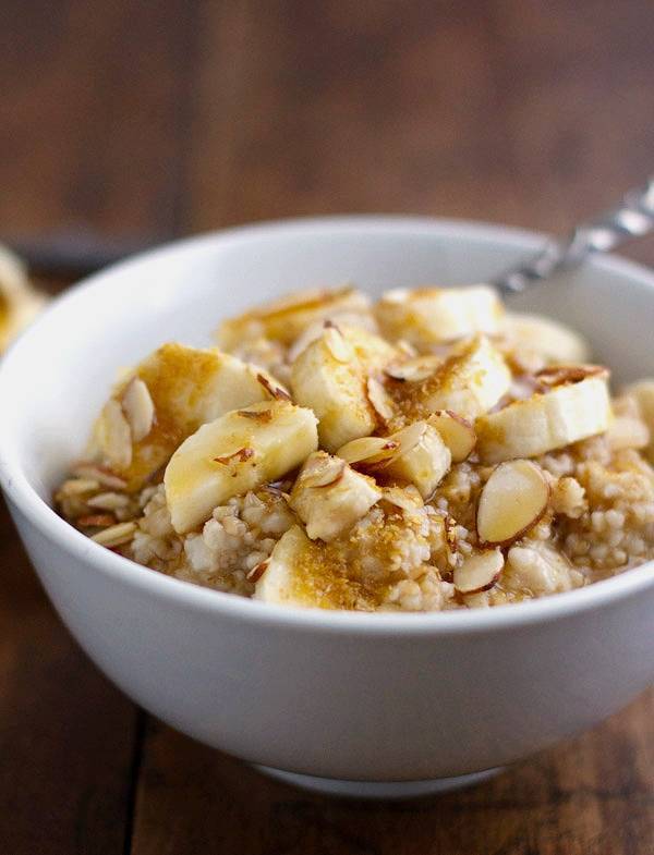 Steel cut oats in a white bowl with bananas.