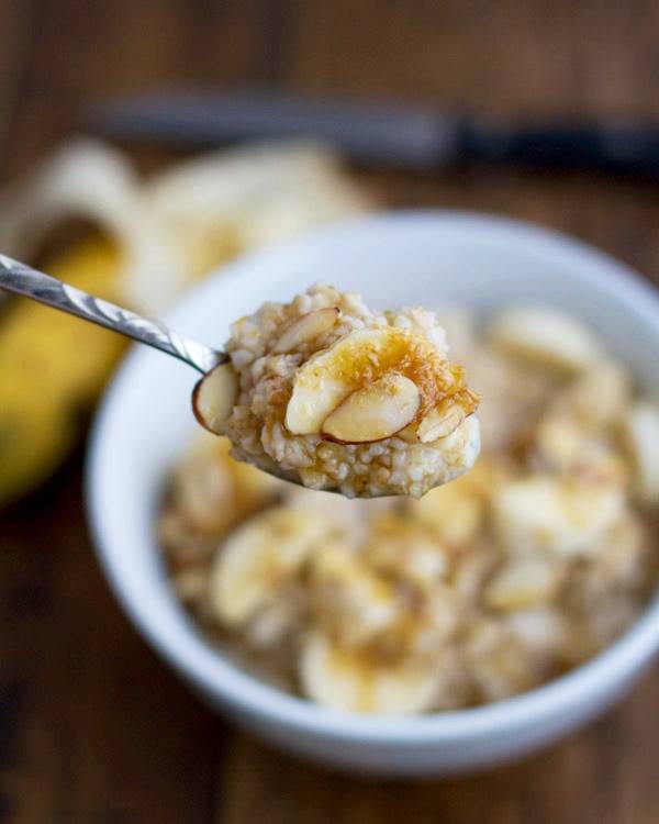 Steel cut oats on a spoon with bananas and almonds.