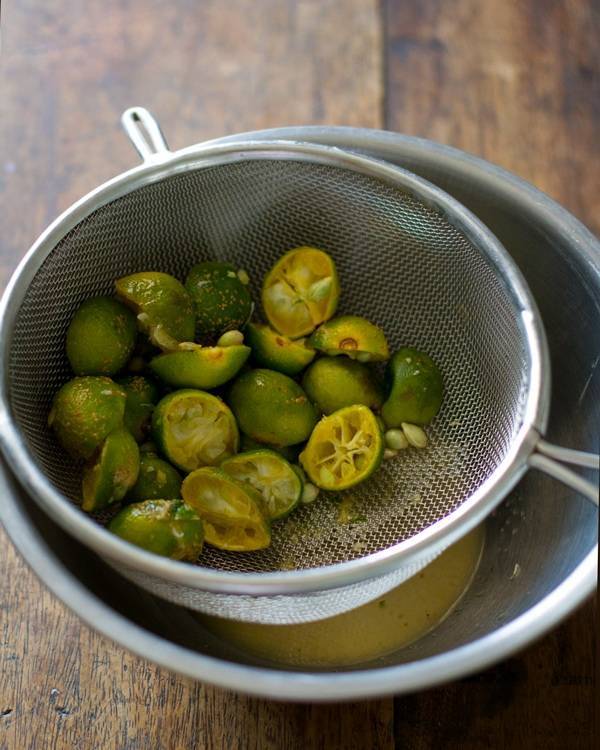 Squeezed limes in a strainer.