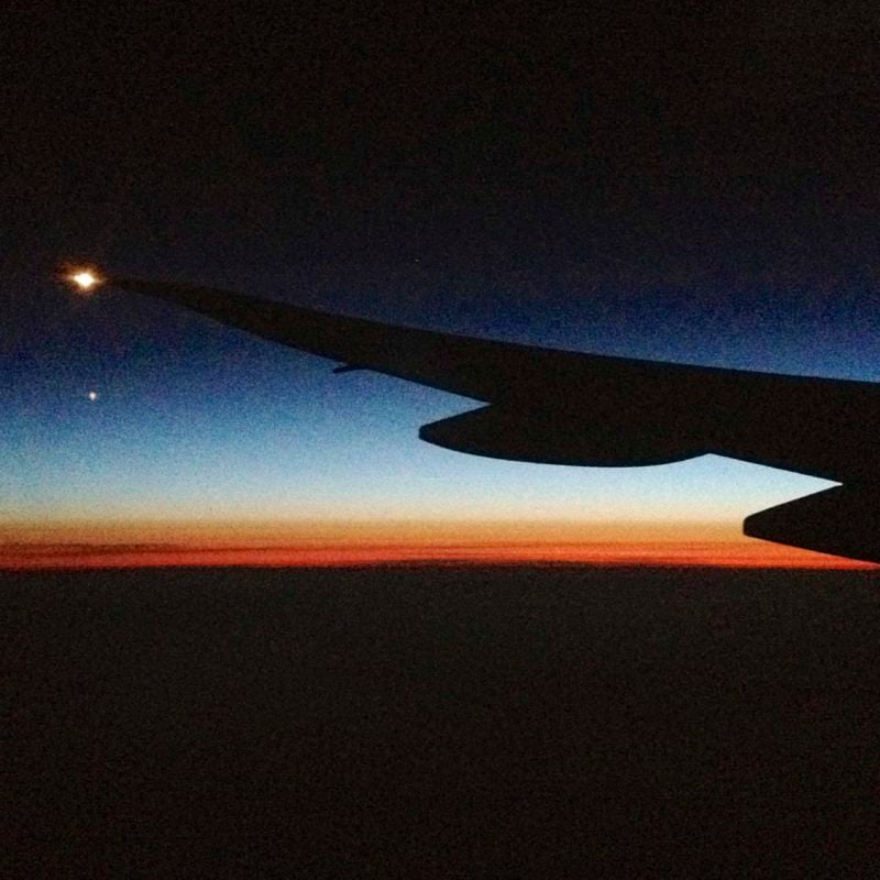 The wing of a plane at sunset.