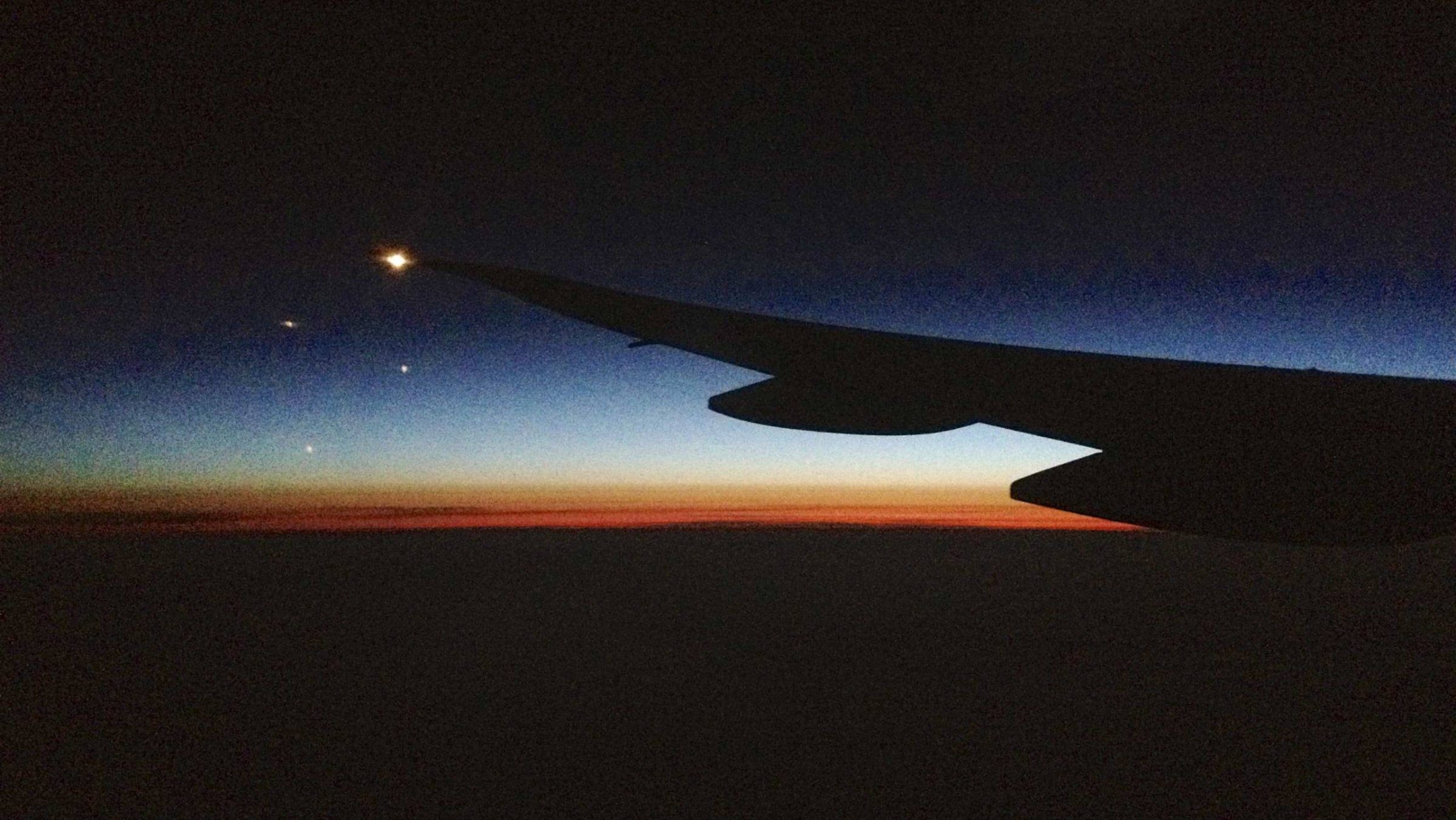 Sunset beyond an airplane wing.