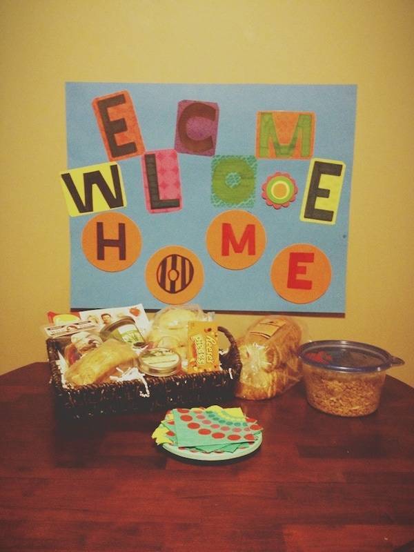 Welcome home sign and food on a table.