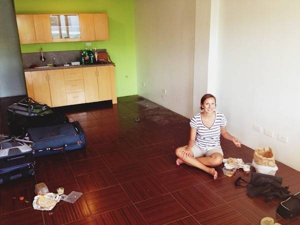 Woman sitting on the wooden floor in an apartment.