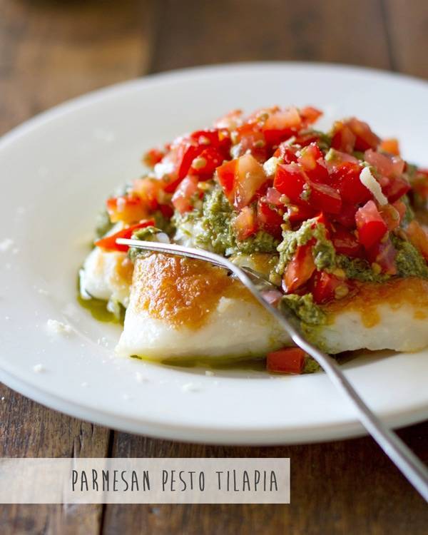 Parmesan pesto tilapia on a plate with a fork.