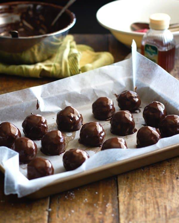 Dark chocolate coconut bites on parchment paper.