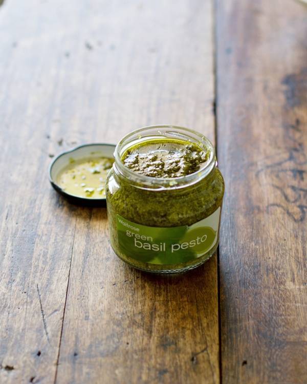 Green basil pesto in a jar.