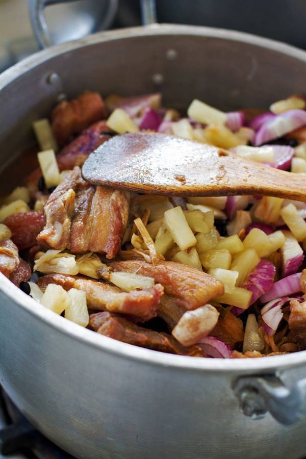 Filipino Humba in a pot with a wooden spoon.