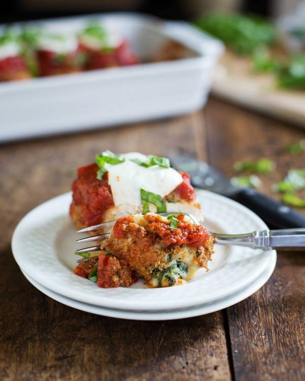 Baked Mozzarella Chicken Rolls on white plates with a fork.