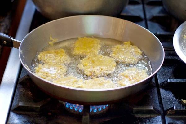 Camote fritters frying in a pan.